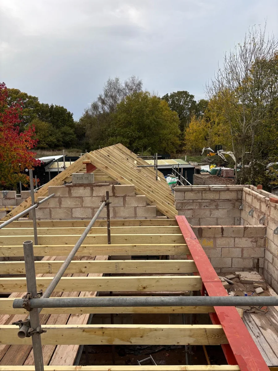 Timber roof framing above new block walls with scaffolding.