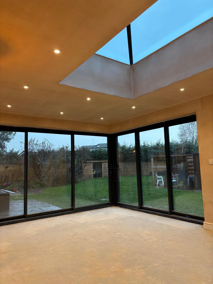 Finished extension interior with a roof lantern and full height glazing onto the garden.