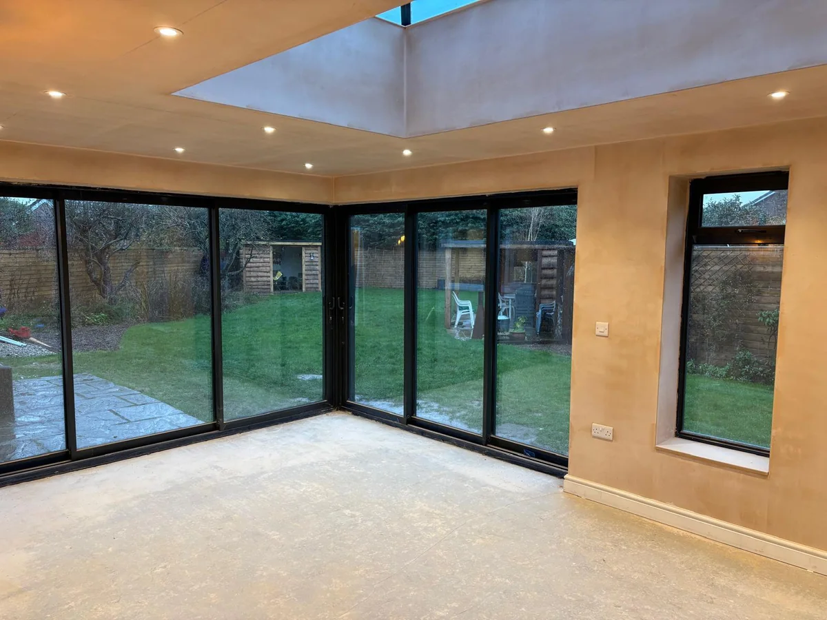 Finished extension interior with corner glazing, spotlights and a roof lantern.