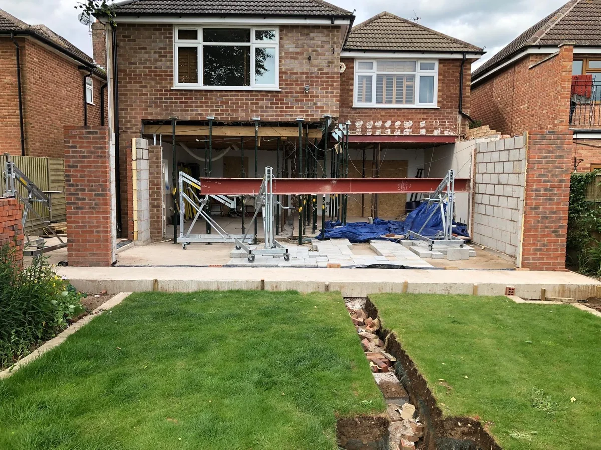 Supported opening in the rear wall of a brick house during extension work.