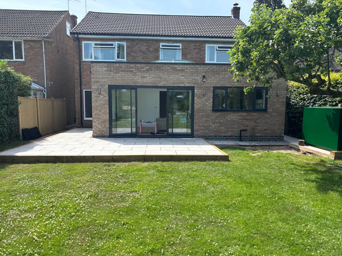 Single-storey brick rear addition with dark framed glazing facing a garden