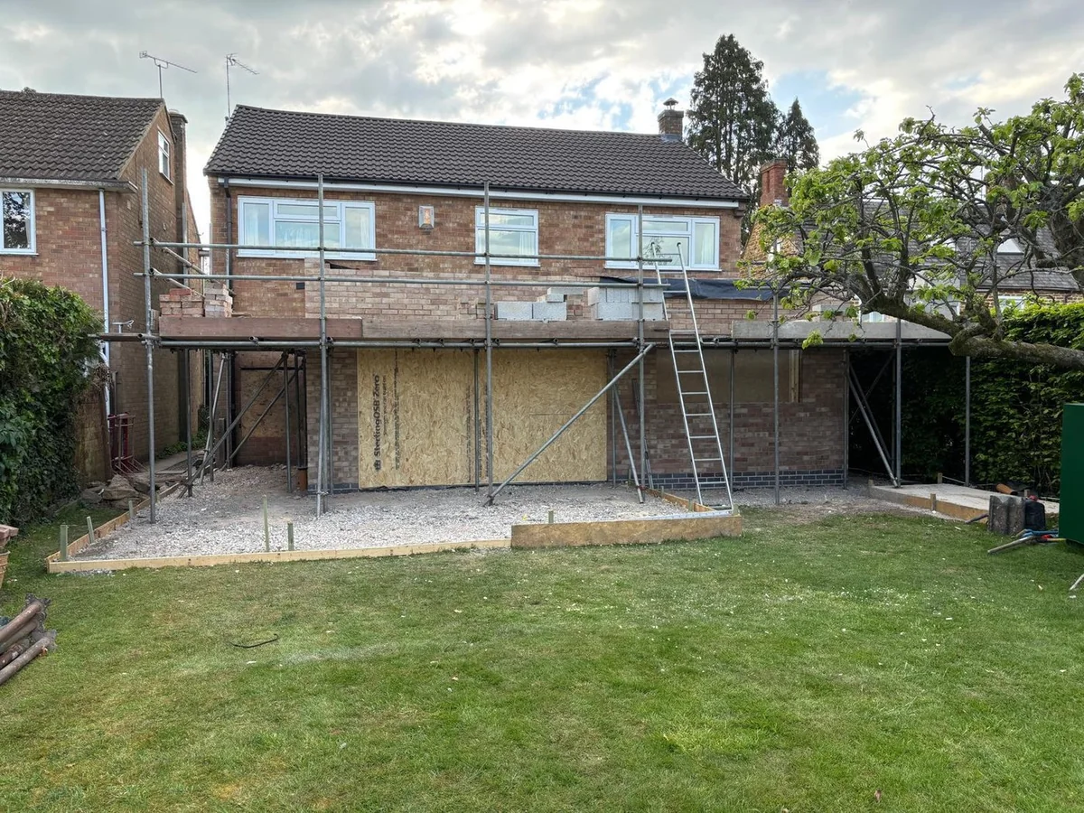 Brick rear addition under scaffolding with open wall sections.
