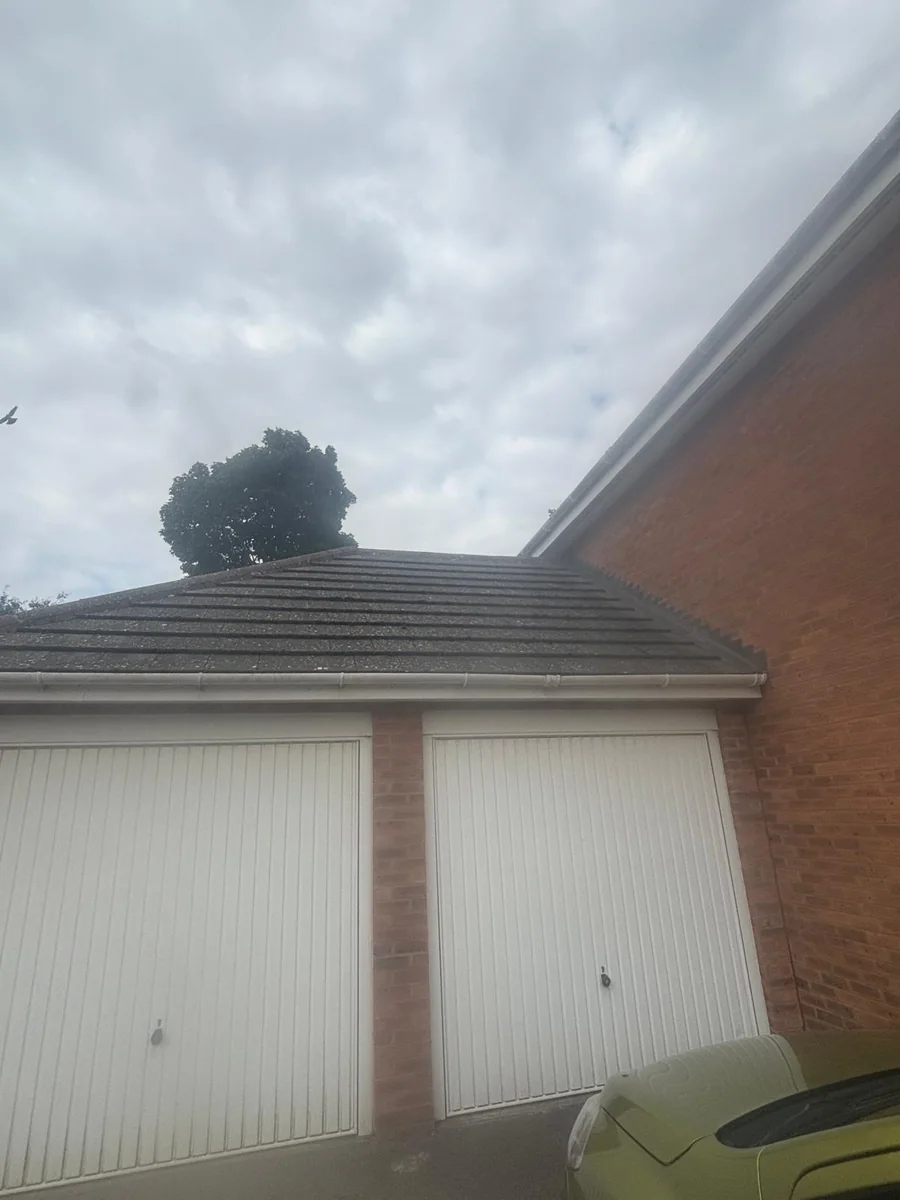Two white up-and-over garage doors below a pitched roof.