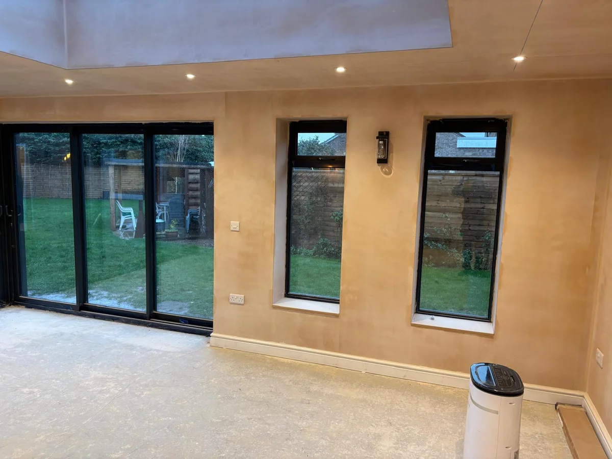 New room with a roof lantern and full height black framed doors